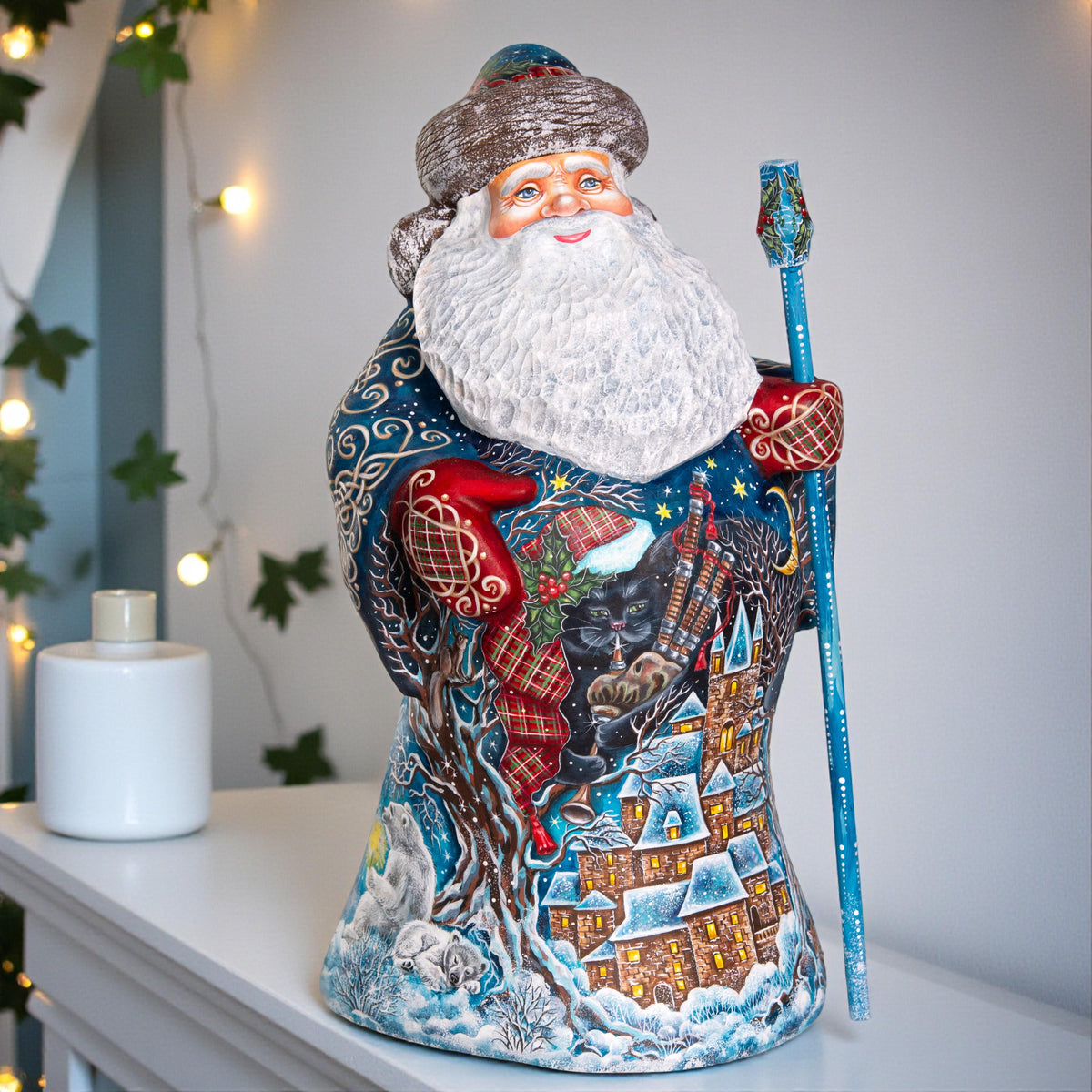 Decorative Santa Claus figurine with a winter scene design on a white surface.